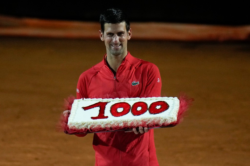 Srbský tenista Novak Djokovič drží tortu s číslicou tisíc