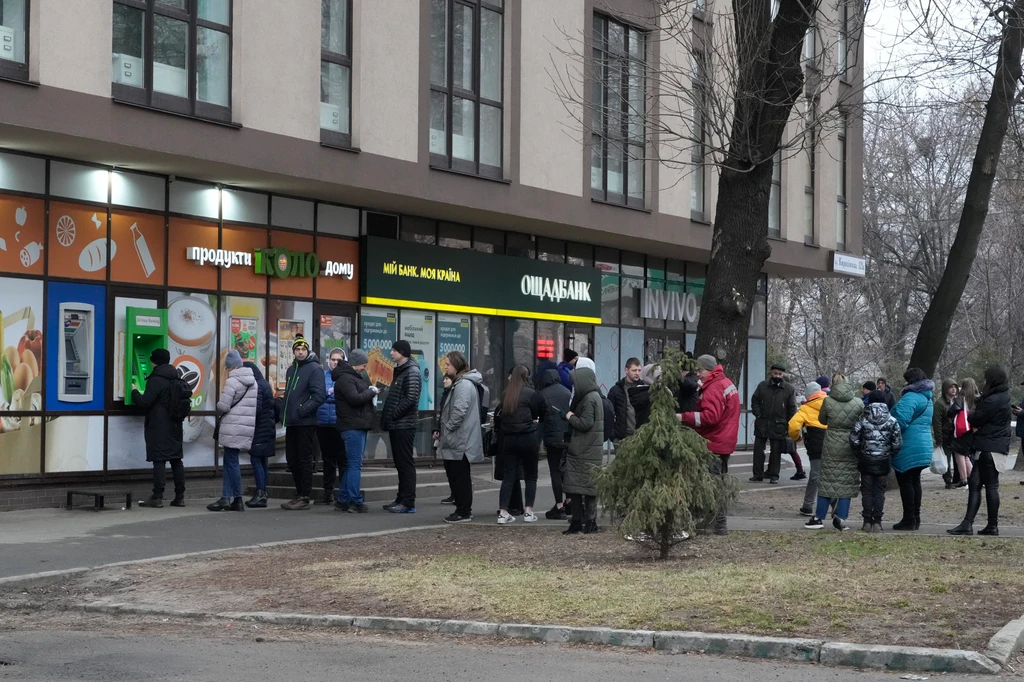 Ľudia čakajú pred bankomatom, aby si vybrali peniaze v Kyjeve