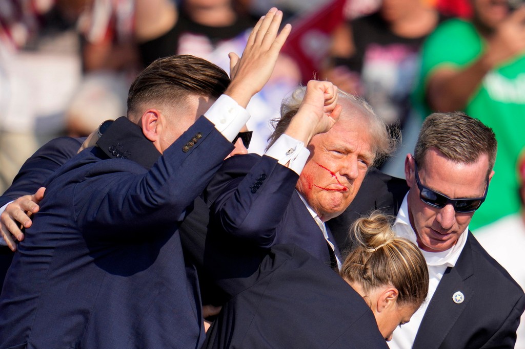 Donaldovi Trumpovi pomáhajú z pódia agenti tajnej služby.