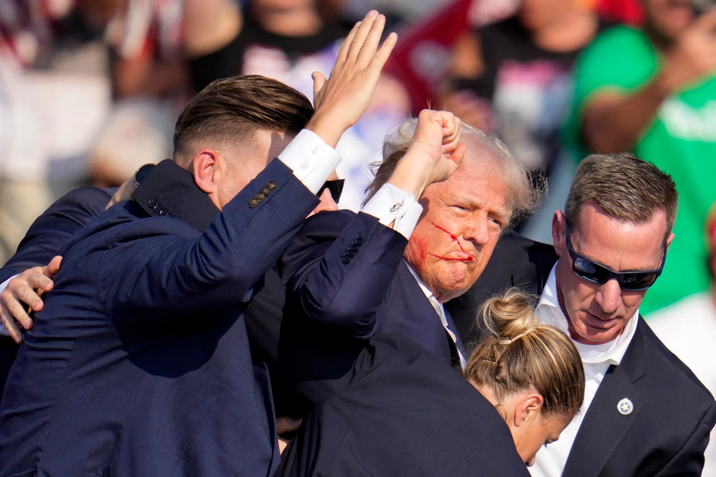 Donaldovi Trumpovi pomáhajú z pódia agenti tajnej služby.