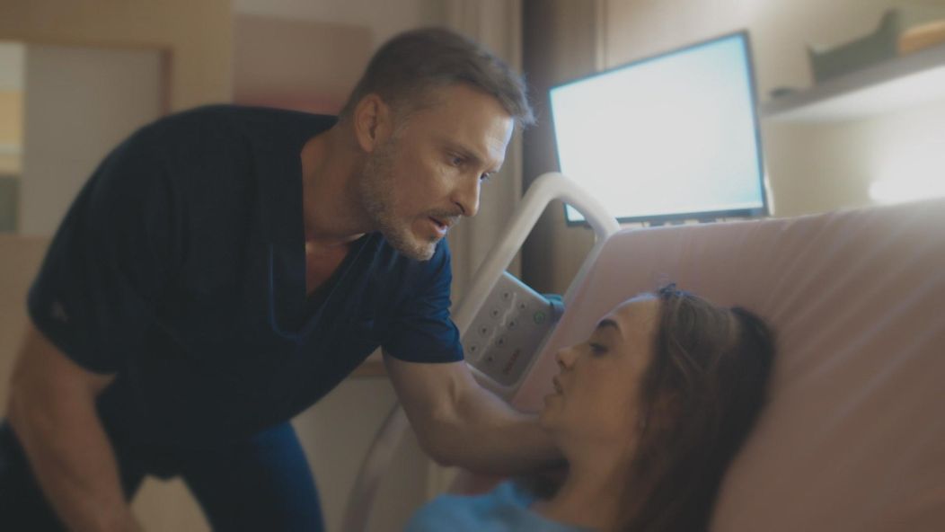 Andrej (Ján Koleník) upokojuje Karolínu (Lucia Šimková) na lôžku.