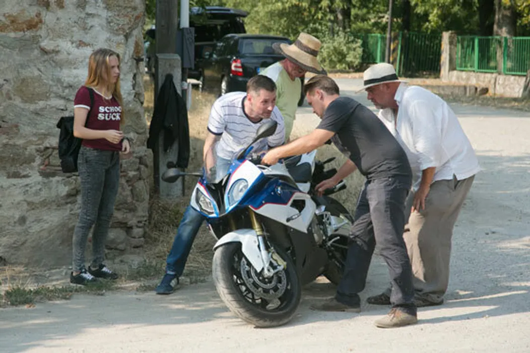 Štáb pomaly spúšťa motorku na zem, tak aby sa nepoškodila