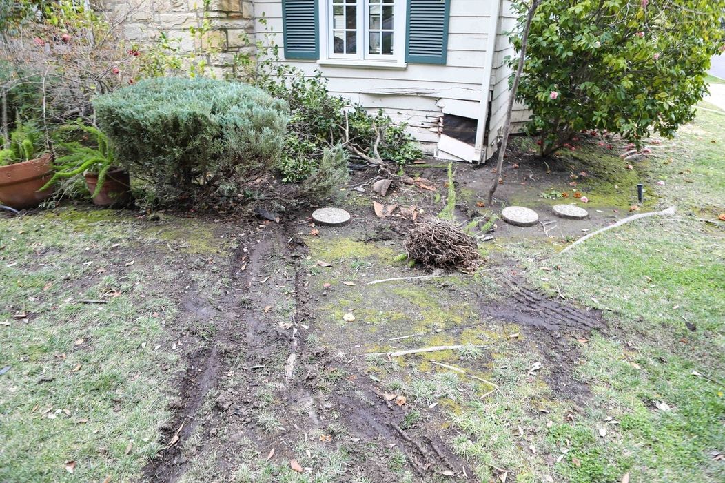 Stopy na trávniku po vozidle, ktoré narazilo do domu