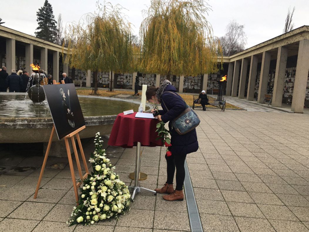 Fanúšička sa podpisuje do kondolenčnej knihy počas rozlúčky s Mekym Žbirkom.