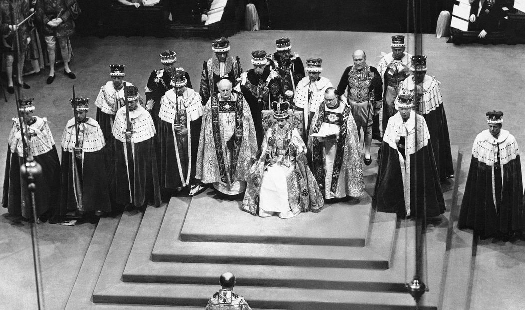 Na archívnej snímke z 2. júna 1953 britská kráľovná Alžbeta II. (uprostred) sedí na tróne po svojej korunovácii vo Westminstersk