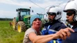 Polícia zatýka ženu počas protestov farmárov na 16. etape Tour de France.