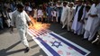 Pálenie izraelskej a americkej vlajky na protestnom zhromaždení v pakistanskom Islamabáde.