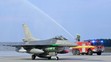 Jedna z dvoch stíhačiek F-16 symbolicky prechádza tzv. slávobránou z hasičských striekačiek v priestoroch Leteckej základne Malacky-Kuchyňa.