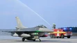 Jedna z dvoch stíhačiek F-16 symbolicky prechádza tzv. slávobránou z hasičských striekačiek v priestoroch Leteckej základne Malacky-Kuchyňa.