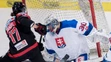 Sprava Denis Godla chytá puk pred Rakúšanom Manuelom Ganahlom v zápase Euro Hockey Challenge.