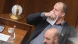 Peter Krupa si prekrýva tvár papierovou vreckovkou a dole Andrej Medvecký (obaja ĽSNS).
