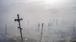 Kríže zahalené dymom z horiacich odpadkov na cintoríne vo vojnou zdevastovanom ukrajinskom meste Mykolajiv.