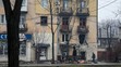 Muž prechádza okolo obytného domu zasiahnutého ostreľovaním v Mariupole na Ukrajine.