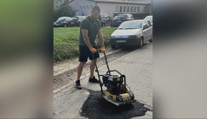 Rozbitú cestu pred bytovkou nie a nie opraviť. Miestny preto chytil stroje do vlastných rúk