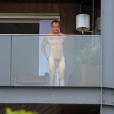 Úplne nahý basgitarista na balkóne. Netrápilo ho, že cez sklo je všetko vidieť