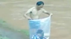Muž vkladá deti do igelitových vriec. Prenáša ich tak cez rieku do školy