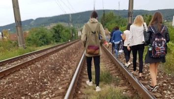 Železniciam sa pokazil vlak. Cestujúci z neho vystúpili a po koľajniciach kráčali na stanicu