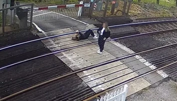 Bezpečnostná kamera zachytila šokujúci moment. Dievča leží na koľajniciach a hrá sa s mobilom