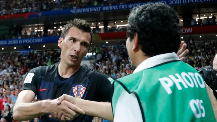 Mario Mandžukič sa ospravedlňuje fotografovi, na ktorého spadol po strelení víťazného gólu proti Anglicku.