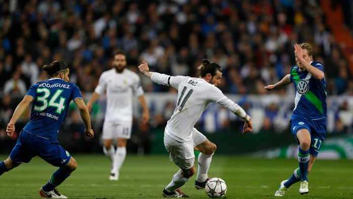 Gareth Bale z Realu Madrid v obkľúčení dvoch protihráčov Wolfsburgu v odvetnom dueli štvrťfinále Ligy majstrov.