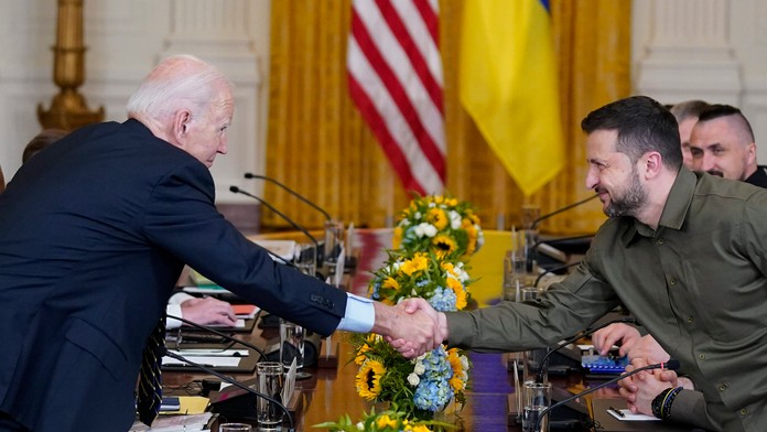  Americký prezident Joe Biden a ukrajinský prezident Volodymyr Zelenskyj si podávajú ruky.