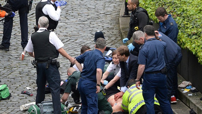 Konzervatívny poslanec Tobias Ellwood (uprostred) pomáha záchranárom.