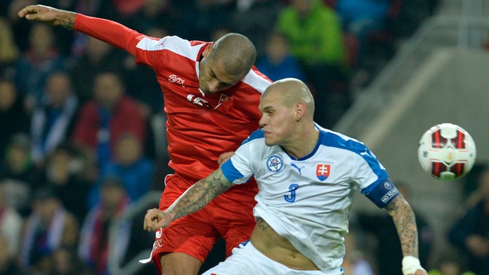 Martin Šrtel bojuje o loptu s Erenom Derdiyokom (Švajčiarsko) v prípravnom zápase na EURO 2016 v Trnave.