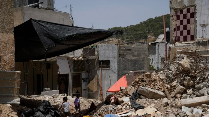 Palestínske deti sa hrajú pri troskách budov, ktoré boli zničené počas operácií izraelskej armády.