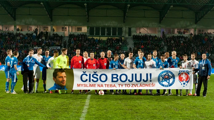 Hráči oboch tímov s transparentom na podporu svojho chorého kolegu.