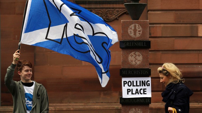 Volič máva vlajkou počas referenda o nezávislosti Škótska v Edinburghu.