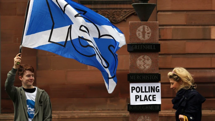 Volič máva vlajkou počas referenda o nezávislosti Škótska v Edinburghu.