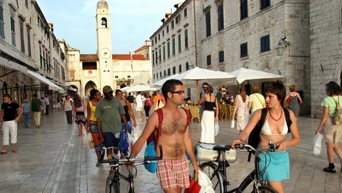 Zahraniční turisti prechádzajú hlavnou ulicou v chorvátskom Dubrovníku.
