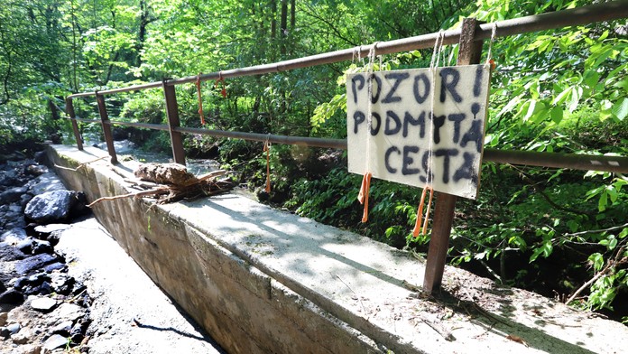 Na snímke je rukou napísaná značka, že je na mieste podmytá cesta.