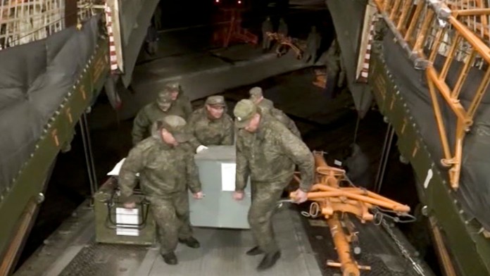 Ruskí vojaci nakladajú armádny materiál do nákladného lietadla na ruskej leteckej základni Humajmím v Sýrii.