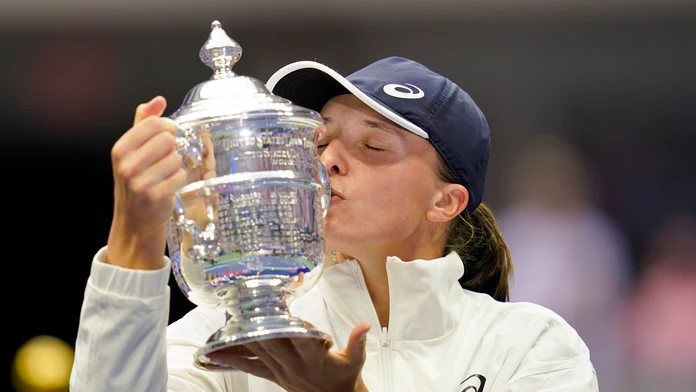 Poľská tenistka Iga Swiateková bozkáva trofej pre víťazku US Open po výhre  nad Tunisankou Ons Jabeurovou 6:2, 7:6.