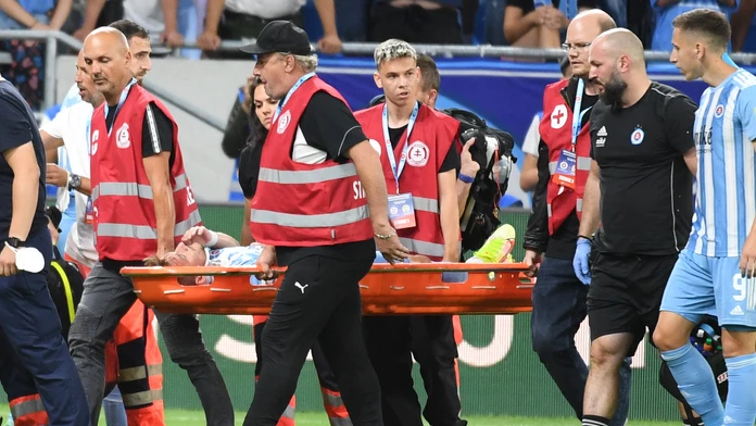 Futbalista Slovana Jurij Medveděv leží na nosidlách počas proti Ferencvárosu. 