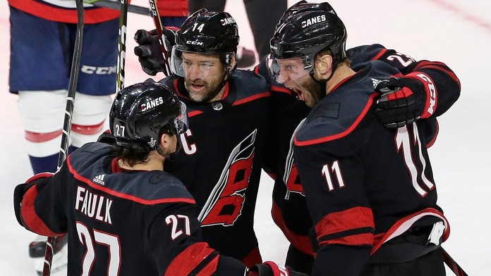 Hokejisti Caroliny Jordan Staal (11), Justin Faulk (27) a Justin Williams (14) sa tešia po strelení gólu.