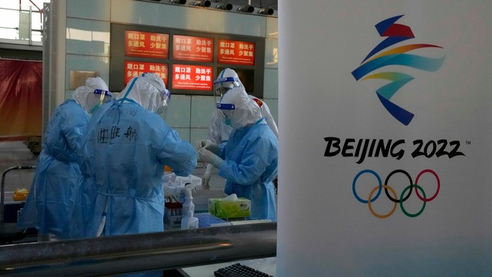 Pracovníci na letisku v Pekingu testujú na covid pred ZOH 2022.