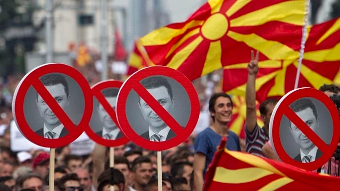 Demonštranti držia transparenty s podobizňou macedónskeho premiéra Nikolu Gruevského počas opozičného zhromaždenia v macedónskej