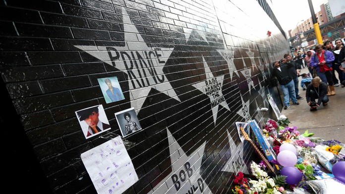 Fanúšikovia pri kvetoch, sviečkach a fotografiách na múre hviezd na First Avenue v americkom Minneapolise