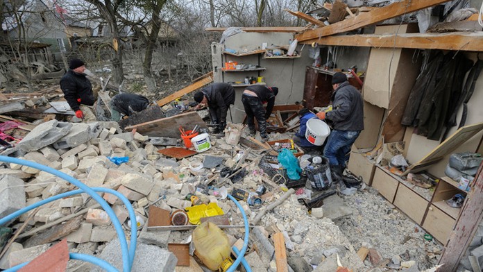 Ľudia odstraňujú materiálne škody na rodinných domoch po raketovom útoku v dedine v Ľvovskej oblasti.