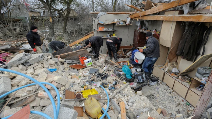 Ľudia odstraňujú materiálne škody na rodinných domoch po raketovom útoku v dedine v Ľvovskej oblasti.