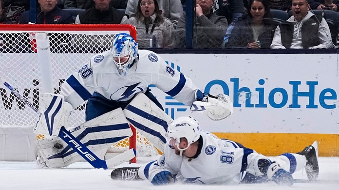 Slovenský obranca v drese Tampy Bay Lightning Erik Černák (vpravo) sleduje puk, ktorý vyráža brankár Tampy Matt Tomkins.