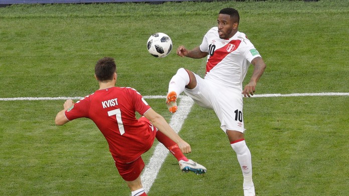 Dánsky futbalista William Kvist (vľavo) a hráč Peru Jefferson Farfan bojujú o loptu.