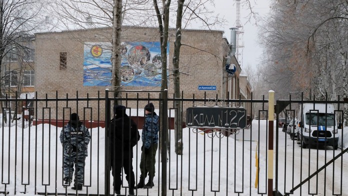 Ruskí policajti hliadkujú pri vchode do strednej školy v ruskom meste Perm.