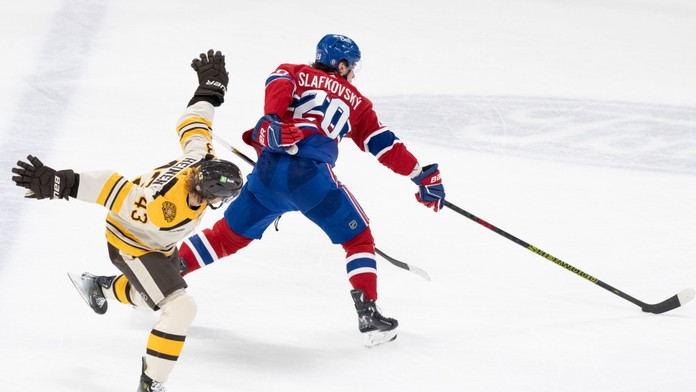 Slovenský hokejista v drese Montrealu Canadiens Juraj Slafkovský (vpravo) a hráč Bostonu Bruins Danton Heinen.