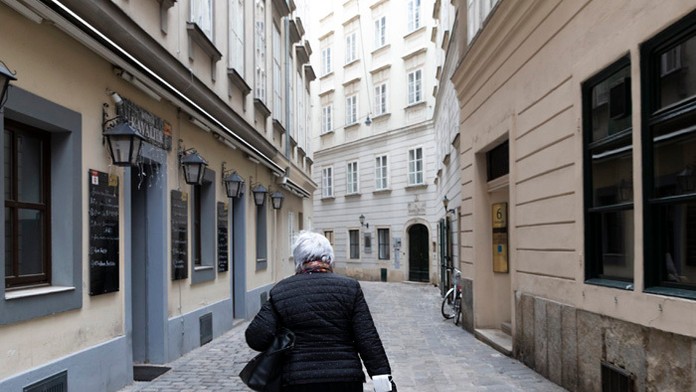  Žena kráča po viedenskej prázdnej ulici počas celoštátneho lockdownu.