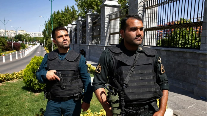Policajti hliadkujú v uliciach Teheránu.