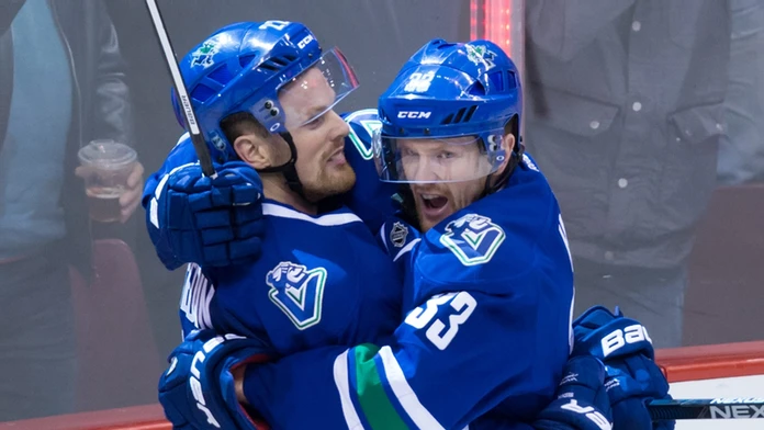 Hokejista Vancouveru Canucks Daniel  Sedin (vľavo) sa teší po strelení gólu so svojím bratom dvojičkou Henrikom..jpg