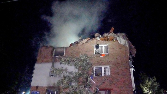 Hasiči hasia požiar bytového domu po raketovom útoku ruskej armády v meste Charkov.